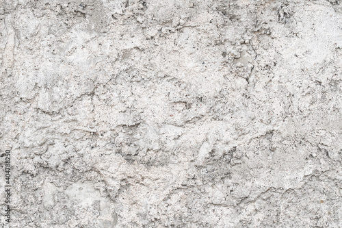 Textured uneven grey plastered or cement wall for background with lots of structural details. Gray shades monochrome