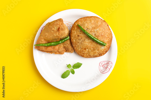 Kachori and potato samosa with green chilly in plate. famous spicy snack in india