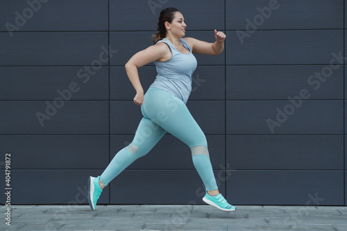 Fat woman jogging, doing sports for weight loss, obesity problem. High quality photo.