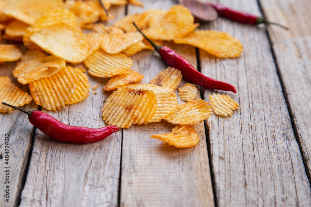 Homemade paprika potato chips on wooden table Homemade paprika potato chips on wooden table