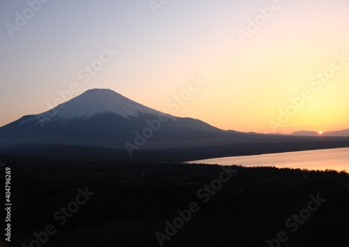 山中湖から見る夕暮れの冨士 山中湖をオレンジ色に染める夕日、遠くには冨士と南アルプス。