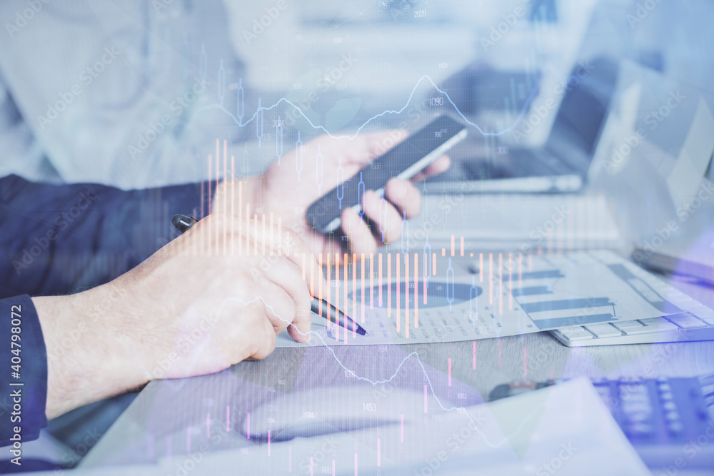 Double exposure of man's hands holding and using a digital device and forex graph drawing. Financial market concept. Double exposure of man's hands holding and using a digital device and forex graph drawing. Financial market concept.