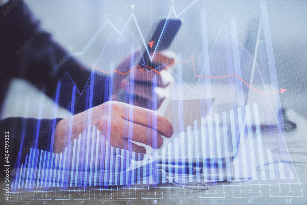 Double exposure of man's hands holding and using a phone and financial graph drawing. Analysis concept. Double exposure of man's hands holding and using a phone and financial graph drawing. Analysis concept.