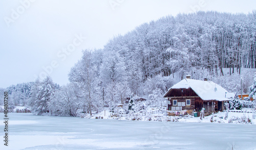 Farm in the forest in winter. Old houses and sheds by the lake. Old agricultural machinery © Dmitry Koshelev