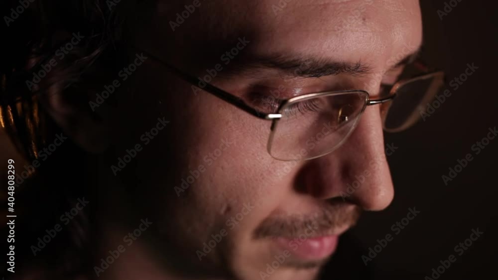 Man in eyeglasses late at night Coder, programmer or developer using laptop in dark. Close up of glasses with reflection of computer screen. Man in eyeglasses late at night Coder, programmer or developer using laptop in dark. Close up of glasses with reflection of computer screen.