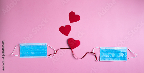 Mascherine chirurgiche legate da un filo rosso per San Valentino. photo