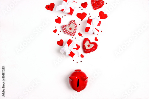Fotografija Piggy bank with gift boxes and hearts on white background