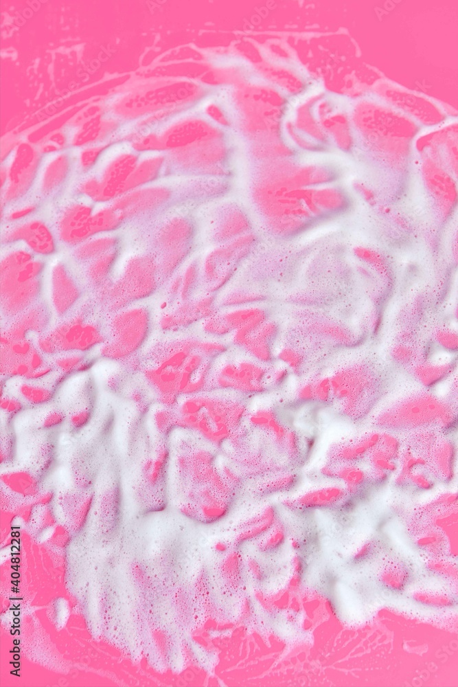 Washing concept. Soap foam on delicate pink background with copy space