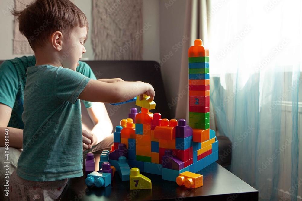 Fototapeta premium Dad and son playing in the constructor. Self-isolation concept for fighting Covid-19