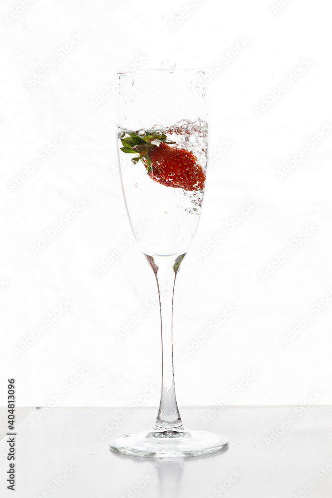 Filling up the champagne glass with strawberry isolated on a white background copy space Filling up the champagne glass with strawberry isolated on a white background copy space