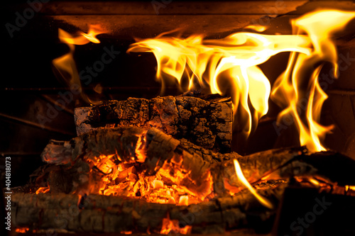 Logs burning in the fire of a fireplace with embers
