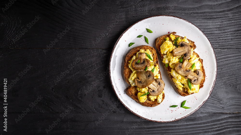 Scrambled eggs and mushrooms on wholewheat toast. Long banner format. space for text