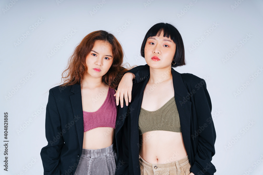 Business fashion portrait of two asian women wearing black suit jacket isolate on white background. Business fashion portrait of two asian women wearing black suit jacket isolate on white background.