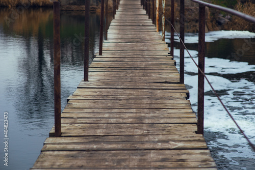 Wet  wooden bridge over the river. Makeshift river crossing