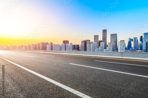Asphalt road and modern city commercial buildings in Beijing at sunrise,China. © ABCDstock