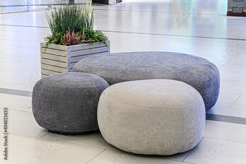 Sitting area in lobby, large shopping center - round ottoman fabric and artificial plants as decoration. Decoration of trading floors, exhibitions, recreation islands in public places. photo