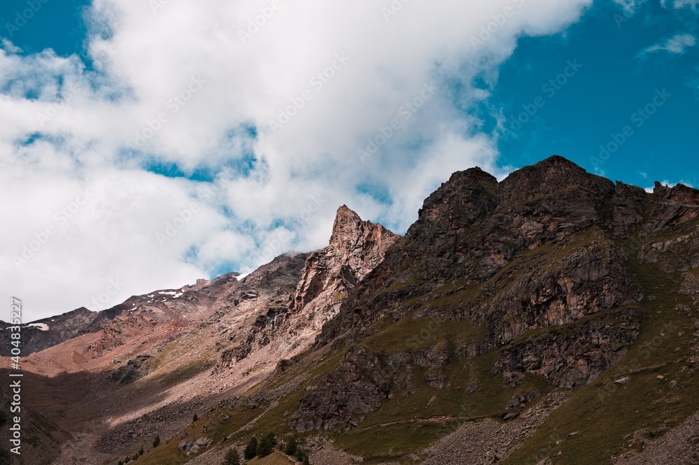 A mountain landscape with clouds in the sky on a summer day in the Italian Alps (Trentino, Italy, Europe)