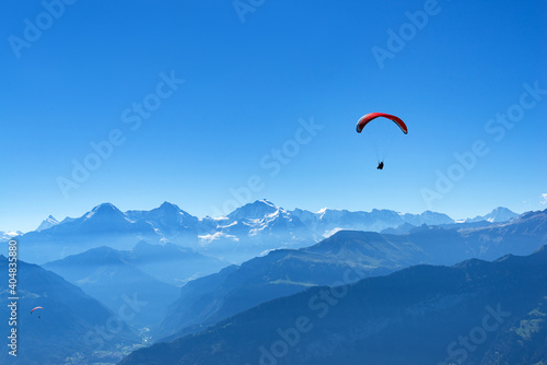 Two hang glider flying in the air in front of the mountains Eiger, Mönch, Jungfrau