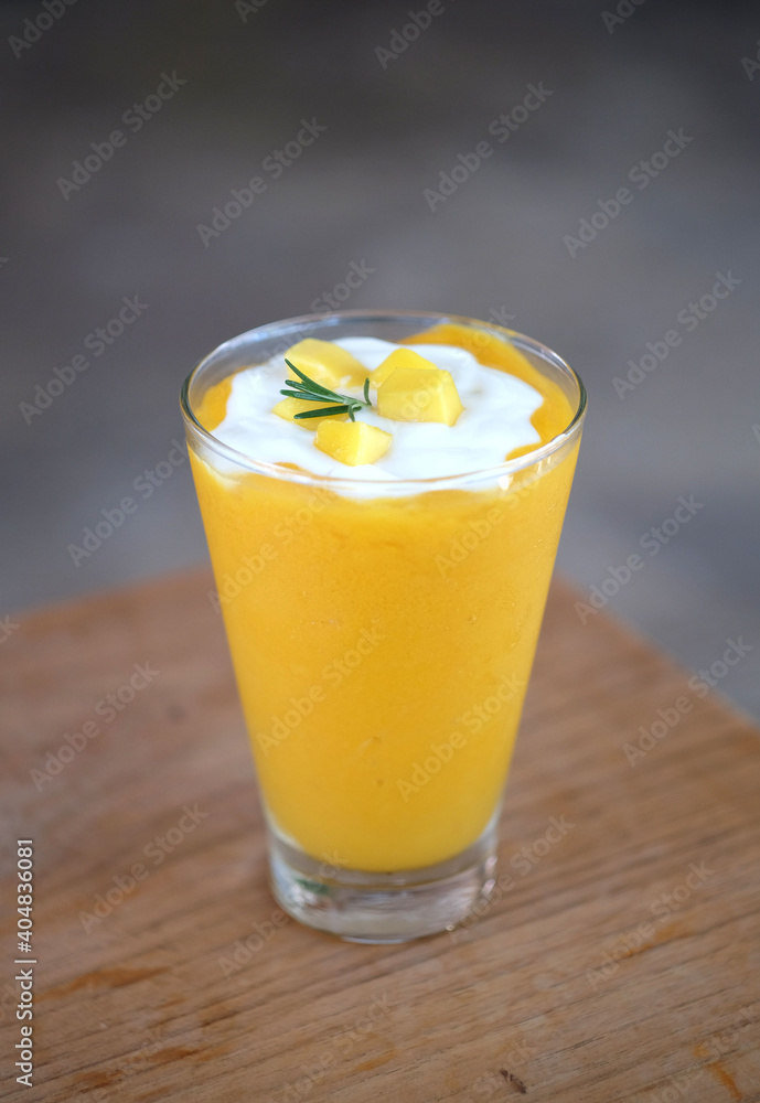 Mango smoothies and yogurt on top in a glass. Tropical fruit summer drink. Mango smoothies and yogurt on top in a glass. Tropical fruit summer drink.