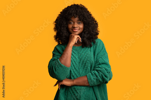 Beautiful young black woman on yellow background