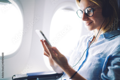 Lady sitting on airplane with cellphone #404842688