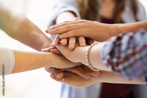 Young multiethnic friends stacking hands photo