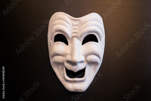 White theatrical mask on a black background. The mask of comedy. Venetian carnival masks.