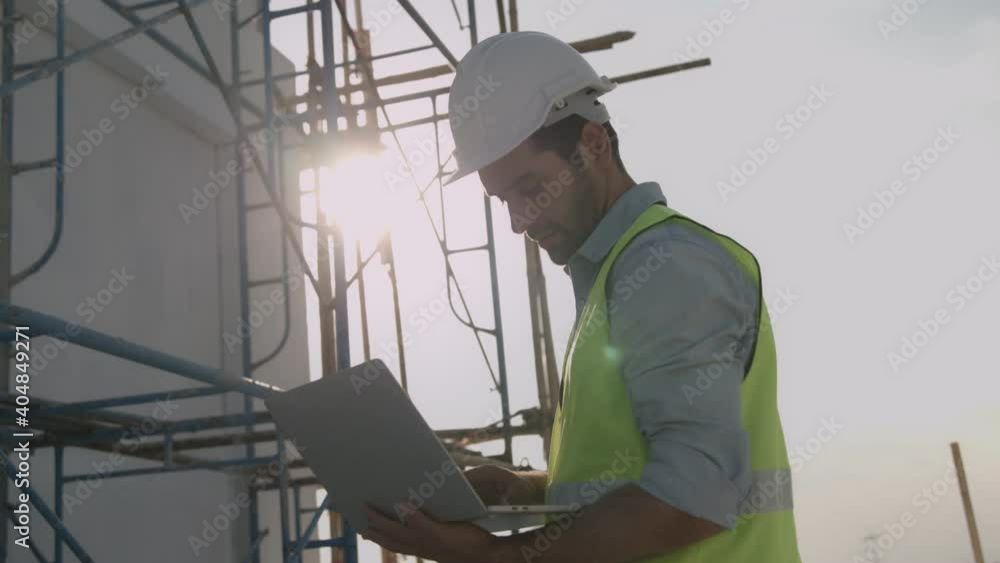 Engineer or inspector wearing white helmet and holding laptop to check and building control, Building exterior structure engineering on rooftop construction site Engineer or inspector wearing white helmet and holding laptop to check and building control, Building exterior structure engineering on rooftop construction site