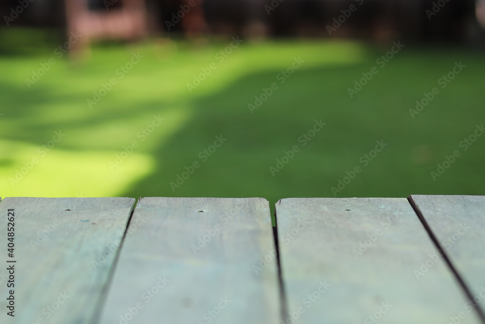 Close up view of wooden table with green field in the background Close up view of wooden table with green field in the background