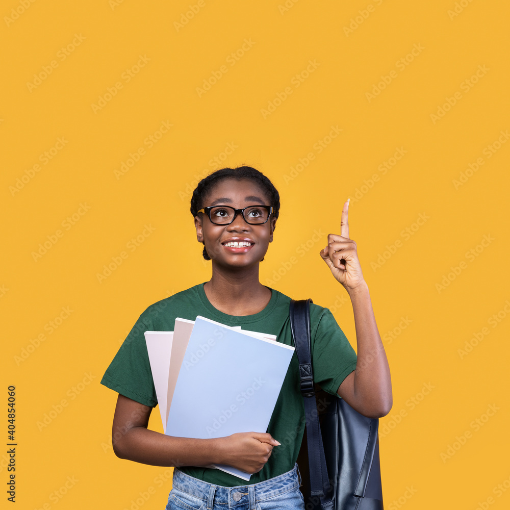 African Student Woman Pointing Finger Up Having Idea, Yellow Background African Student Woman Pointing Finger Up Having Idea, Yellow Background