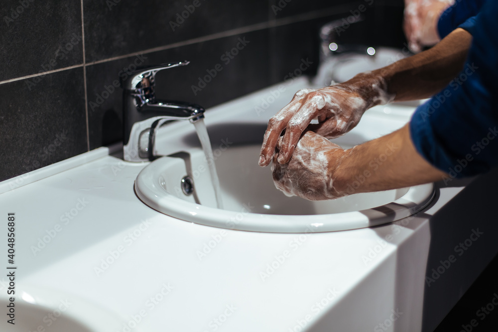 close up. young people wash their hands in a public restroom