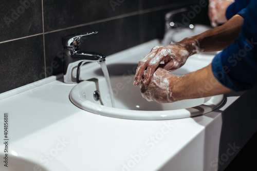 Obraz na płótnie close up. young people wash their hands in a public restroom w salonie