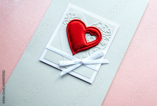 Valentine s day greeting card with a red heart isolated on a light pink background