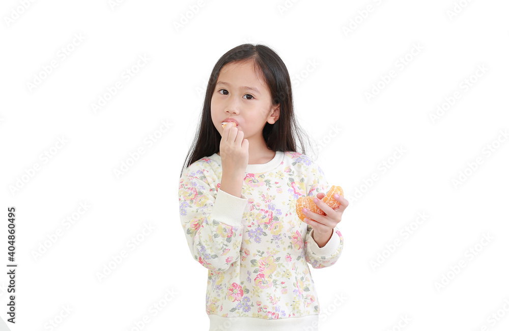 Portrait little asian kid girl eating orange fruit on white background Portrait little asian kid girl eating orange fruit on white background