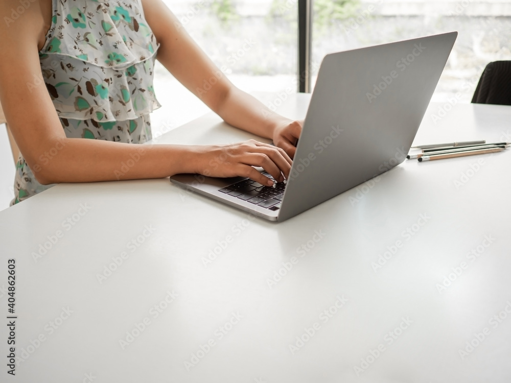Fototapeta premium Woman sitting at desk and working at computer hands close up, Businesswoman typing on laptop at workplace Woman working in home office hand keyboard