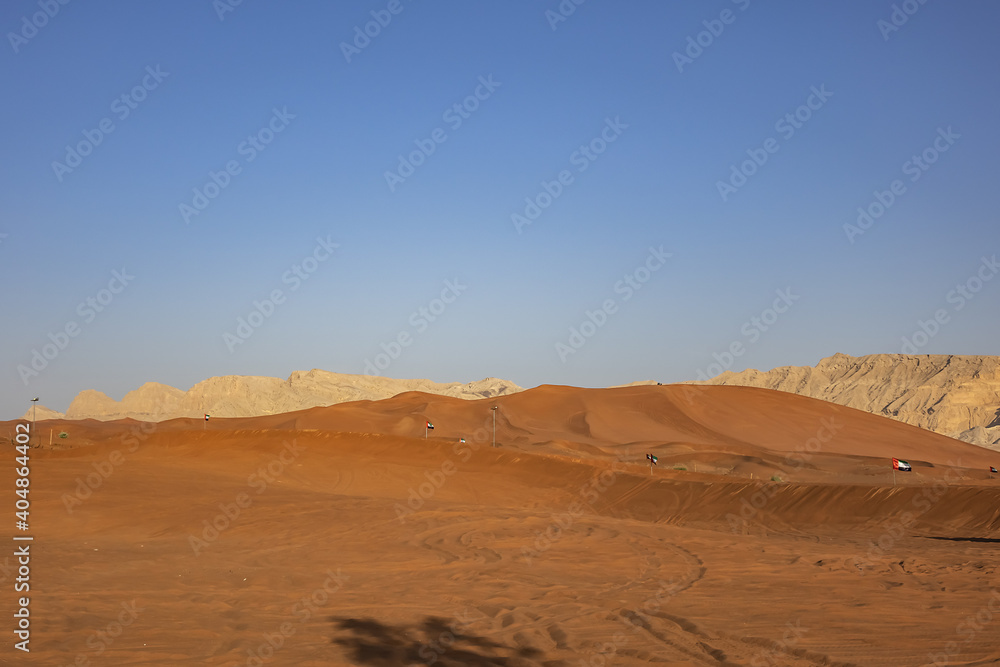 Desert dunes at Al Awir desert near Dubai with buggy vehicle at sunset light. Dubai, United Arab Emirates, Middle East.