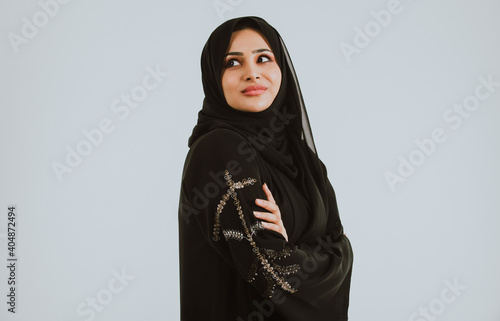 Beautiful woman from Dubai posing on colored background with traditional abaya Fototapeta