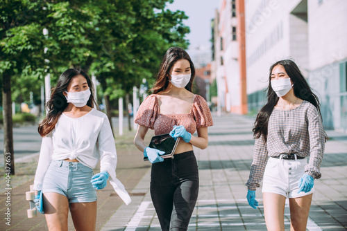 Group of asian girls going out after quarantine during coronavirus period. Young women outdoor with safety masks