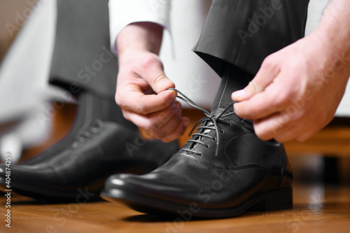 Man tying shoelaces on black shoes