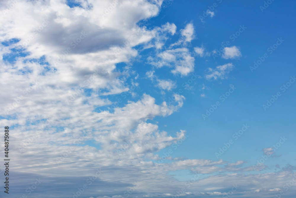 White clouds gradually leave the blue sky, dividing it into two sections White clouds gradually leave the blue sky, dividing it into two sections