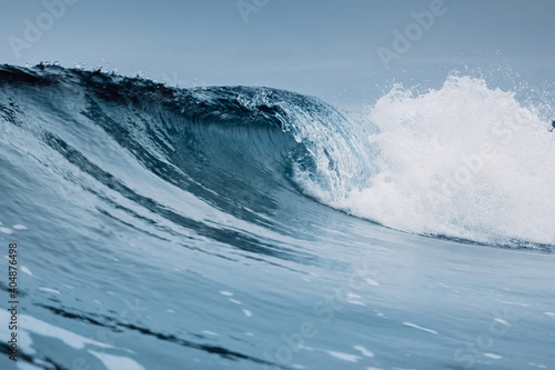 Fototapeta Naklejka Na Ścianę i Meble -  Crashing glassy wave and cloudy sky. Breaking ocean waves, perfect swell for surfing