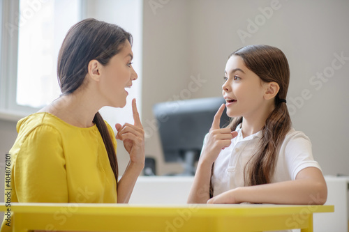 Woman and girl sitting opposite each other