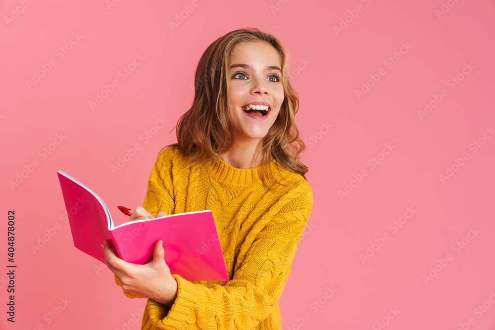 Happy beautiful blonde girl smiling while writing in exercise book Happy beautiful blonde girl smiling while writing in exercise book