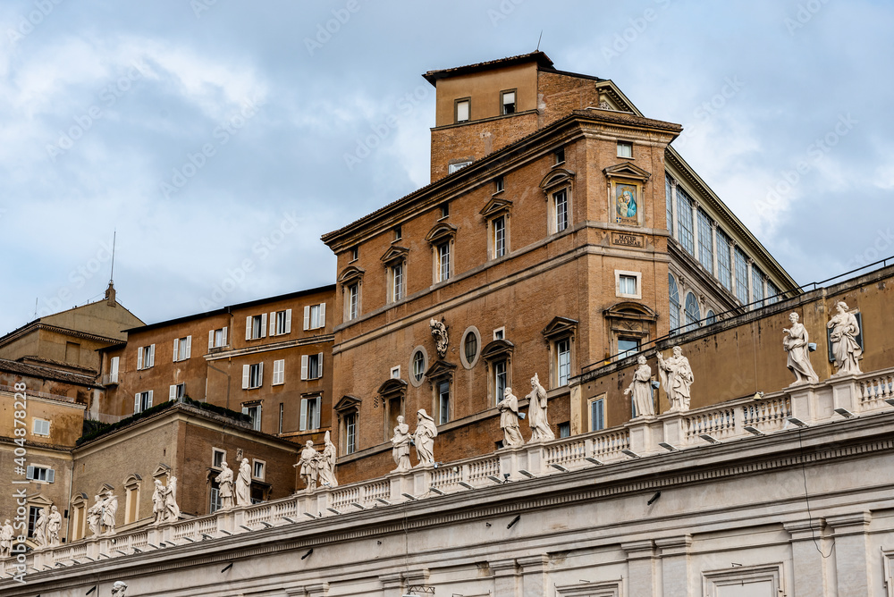 Wall with sculptures and different shapes of buildings in the Vatican, view from Rome