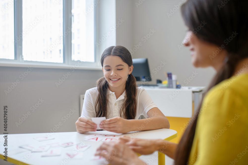 Involved girl playing at table with cards Involved girl playing at table with cards