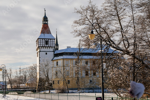 Medieval renaissance water castle with half-timbered tower with snow in winter sunny day, Historic Romantic chateau Blatna near Strakonice in southern Bohemia, Czech Republic photo