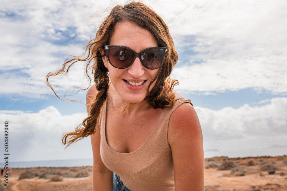 Young girl with summer clothes and sunglasses smiling at camera Young girl with summer clothes and sunglasses smiling at camera