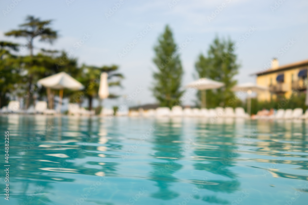 Beautiful house, swimming pool view from the veranda, summer day Beautiful house, swimming pool view from the veranda, summer day