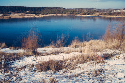 Lake in the middle of the forest with blue water on a sunny early spring day