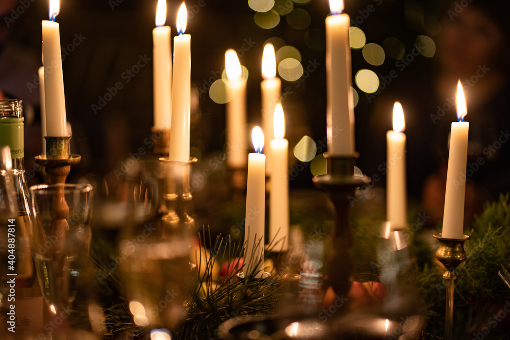 burning candles in candlesticks in a dark interior. romantic dinner. New Year's and Christmas decor. Lighting the room. Low light. Selective focus. bokeh burning candles in candlesticks in a dark interior. romantic dinner. New Year's and Christmas decor. Lighting the room. Low light. Selective focus. bokeh